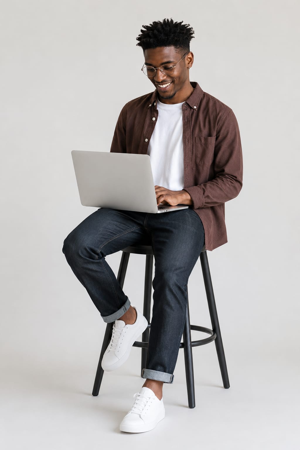 Estudante sentado em um banco alto, estudando em um notebook